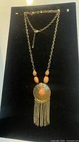 Full view of necklace showing pendant, tassel and adjustable chain