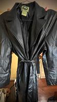 Front view of black leather trench coat with belt