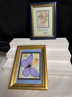 Both framed prints: Bergsma lithograph (top), butterfly print (bottom)
