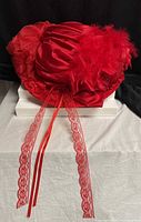 Full view of red Derby hat with lace streamers