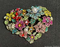 Front view of heart brooch showing multicolored rhinestones and faux pearls