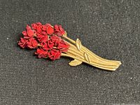 Full view of brooch showing bouquet shape, red roses, gold stems