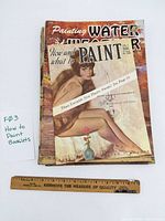 Front view showing stack of booklets with ruler for scale