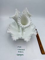 Front view of milk glass epergne showing three horns and ruffled rim