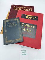 Three vintage atlases stacked showing covers