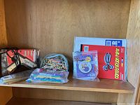 Shelf view showing glue guns, glue sticks, crayons, coloured pencils/markers, construction paper pads