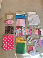 Overview of entire lot on floor showing gift bags, boxes, mailers