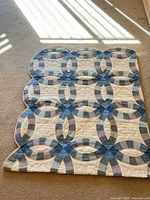 Full view of quilt front showing Double Wedding Ring pattern and scalloped edges