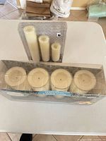 Two sealed packages of flameless LED pillar candles, four-pack and three-pack