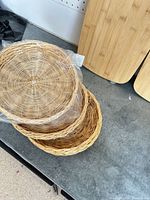 Stack of three wicker baskets on work surface with bamboo boards partially visible