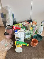 Full lot overview showing sprayers, jug, fertilizer bags, planters, netting