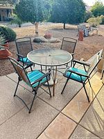 Full view of round table with four chairs and cushions