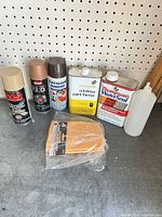 All seven items grouped: three spray paint cans, paint thinner can, waterproofer can, cloth pack, squeeze bottle