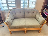 Front view of rattan loveseat with cushions