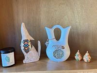 Group shot showing candle, coyote figurine, wedding vase and both bird figurines