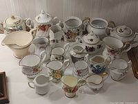 Group of 20 vintage creamers and sugar bowls on table