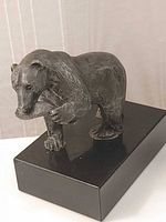 Three-quarter view of bear sculpture on base