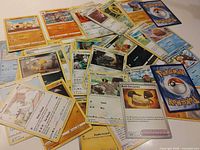 Pile of assorted Pokémon cards spread out showing fronts and one back