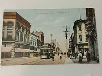 Front of colorized postcard showing Government Street with streetcar, pedestrians, cyclists and numbered caption