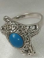 Top view of sterling silver turtle ring showing turquoise cabochon and filigree detail