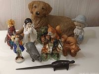 Group shot showing majority of figurines including retriever, ebony turtle, porcelain figures, mini mugs and decorative rod