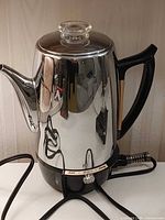 Full view of chrome General Electric electric coffee percolator with cord attached