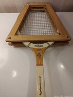 Racquet inside wooden press showing frame and strings