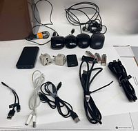 All items laid out including mice, cables, adapters, chargers, power bank, flash drives