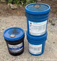 Three buckets: two blue Chevron Rando HD 68 and one black STP Hydraulic Oil
