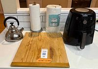 Group shot showing air fryer, tea kettle, cutting board, paper towel holder