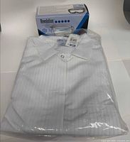 Lab coat in sealed plastic with goggles box behind