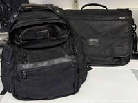 Backpack and briefcase side by side showing overall forms and size relation