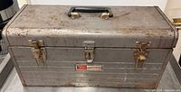 Front view of gray Sears Craftsman toolbox with handle and latches