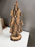 Full view of wooden tree sculpture showing bark texture and base
