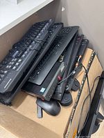 Stack of five keyboards and three mice in cardboard box