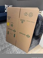 Stack of flattened Stericycle small moving boxes with printed size and logos visible