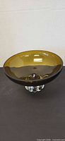 Amber glass bowl on clear foot, frontal view