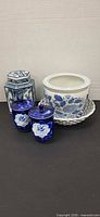 Group shot of tea caddy, two cobalt lidded cups, planter and lace bowl