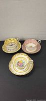 Three cup and saucer sets displayed