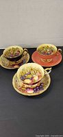 Three Aynsley cup and saucer sets, assorted exterior colours