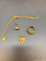 Overall view of four jewelry pieces on dark surface