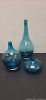 All three blue glass vases grouped together