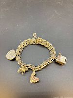 Full view of sterling link charm bracelet with four charms attached