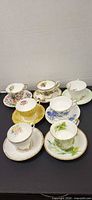 Eight vintage teacup and saucer sets displayed
