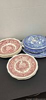 Stack of Mason's Vista red plates beside Myott blue casserole with platter