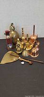 Group view of all copper and brass bells, crumb pan and baton