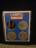 Front of sleeve with three silver-tone Carnaval tokens and empty slot