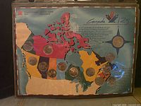 Front of set showing thirteen quarters mounted on colourful map card inside plastic sleeve