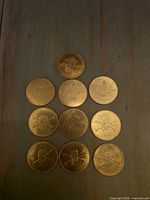 Ten brass arcade tokens arranged in pyramid, showing both obverse and reverse designs