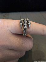 Ring on finger showing three claw tips